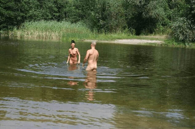 Heimliches Voyeur Bild zeigt nacktes Paar beim Baden am See